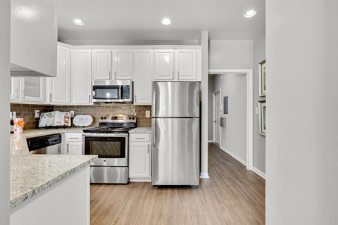 a kitchen with white cabinets and stainless steel appliances