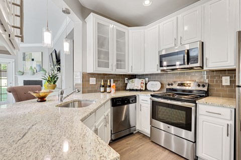 a kitchen with white cabinets and a granite counter top