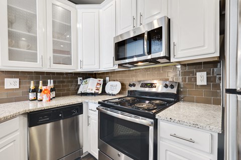 a kitchen with white cabinets and stainless steel appliances
