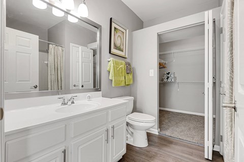 a bathroom with white cabinets and a white toilet