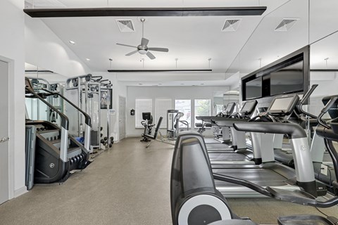 a room filled with cardio equipment and a flat screen tv