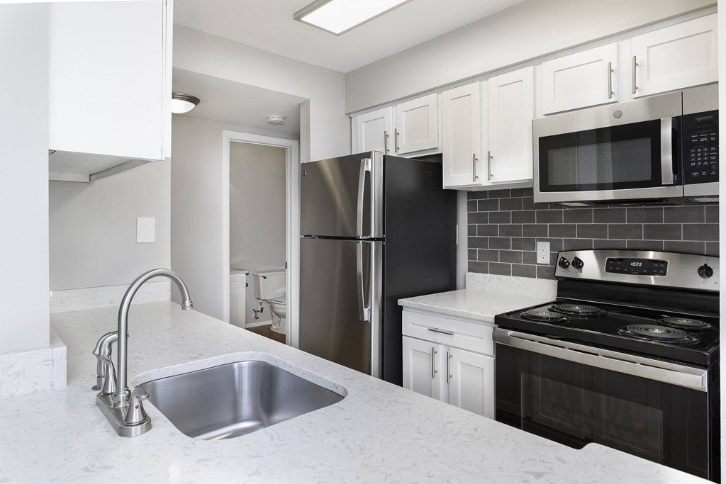 Renovated unit with granite countertops and subway tile backsplash