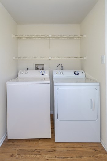 In-unit laundry with built-in shelving at Springwoods at Lake Ridge apartments for rent in Woodbridge, VA - Photo Gallery 30