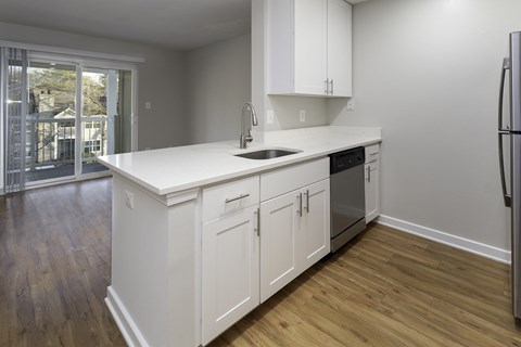 a kitchen with white cabinets and a large island with a sink