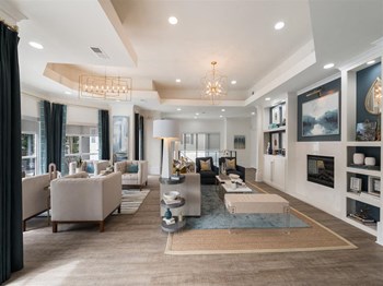 Resident clubhouse with sofas, chandeliers, a fireplace and wood-designed flooring at Chace Lake Villas apartments in Birmingham, AL Resident clubhouse with sofas, chandeliers, a fireplace and wood-designed flooring at Chace Lake Villas apartments in Birmingham, AL - Photo Gallery 5