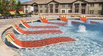 In-water lounge chairs at one end of the resort-style swimming pool at The Retreat at Fairhope Village in Fairhope, AL - Photo Gallery 4