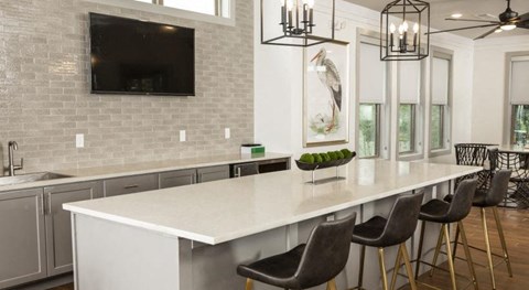 a kitchen with a white counter top and chairs