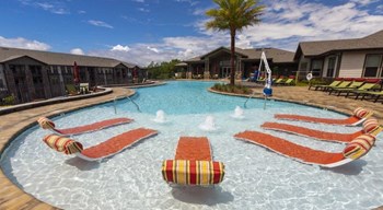 In-water lounge chairs at one end of the resort-style swimming pool at The Retreat at Fairhope Village in Fairhope, AL - Photo Gallery 3