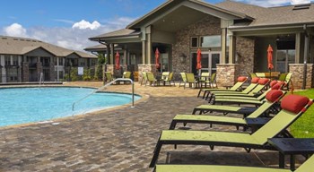 Green lounge chairs and wide sundeck surrounding the resort-style swimming pool at The Retreat at Fairhope Village in Fairhope, AL - Photo Gallery 5