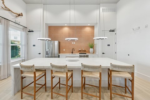 A modern kitchen with a white table and chairs.