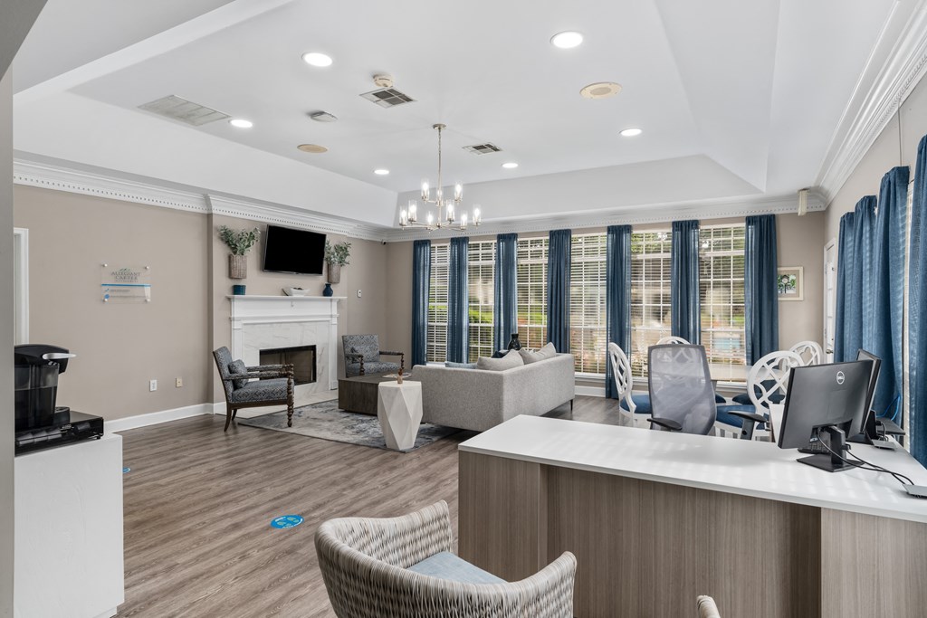 a resident clubhouse with couches chairs and a fireplace