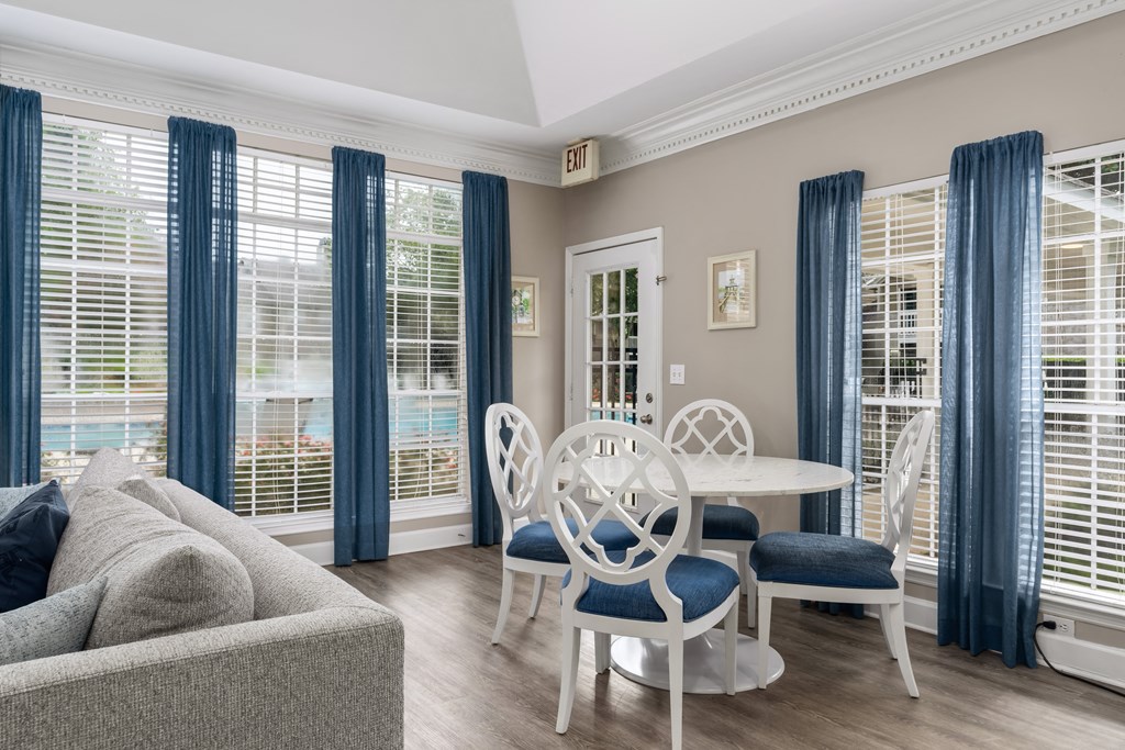 a seating area with a sofa table and chairs