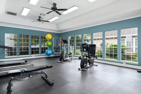 a home gym with exercise equipment and windows
