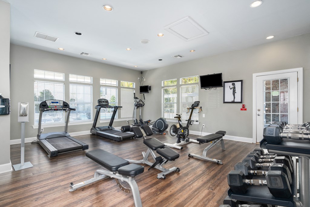 the gym has plenty of exercise equipment and windows