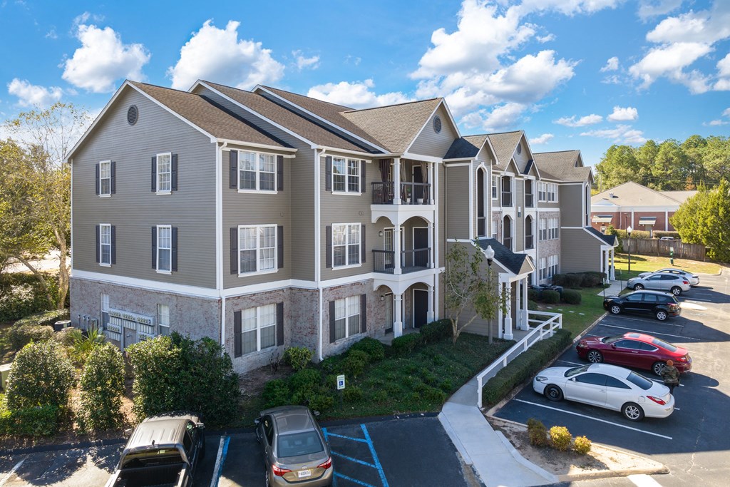 an aerial view of an apartment complex with cars parked in a parking lot