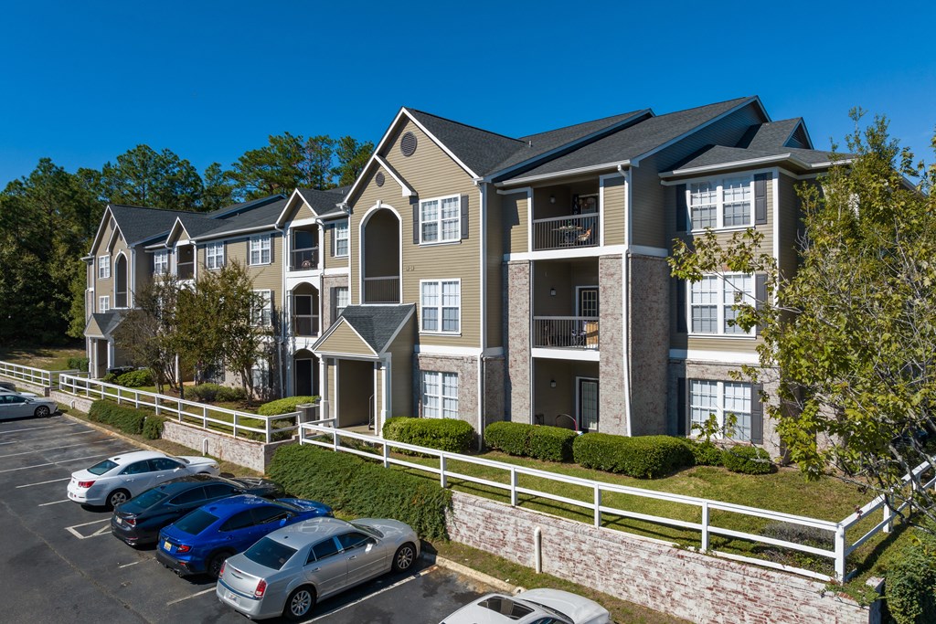 an apartment building with cars parked in front of it