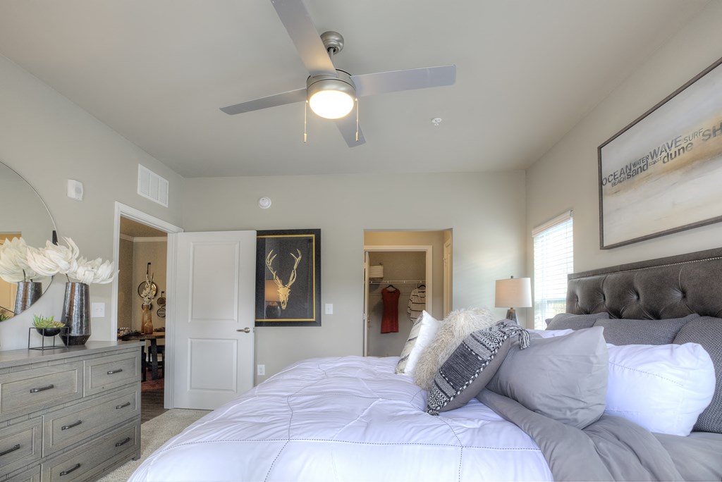 Furnished model bedroom with walk-in closet and private bath at Lullwater at Blair Stone
