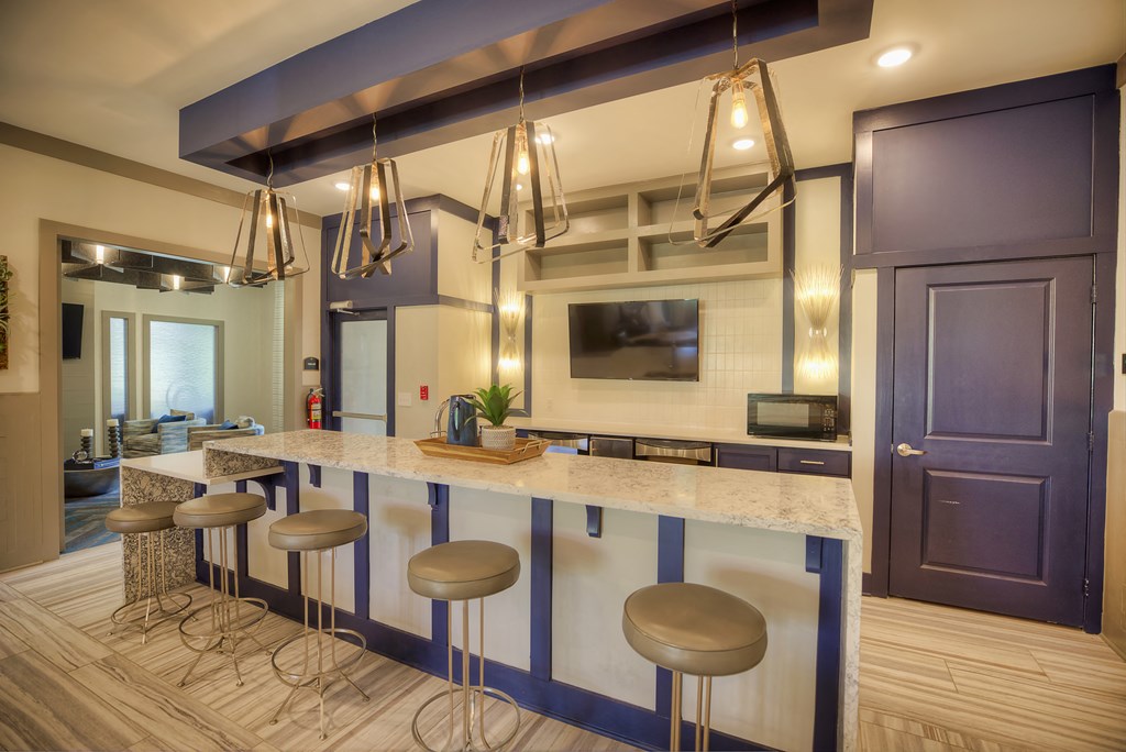 Communal kitchen with bar-style seating and TV at Lullwater at Blair Stone