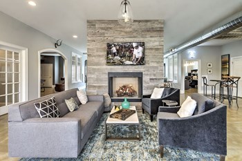Clube house at The Retreat at the Park in Burlington, NC furnished with a couch and chairs in front of the fireplace