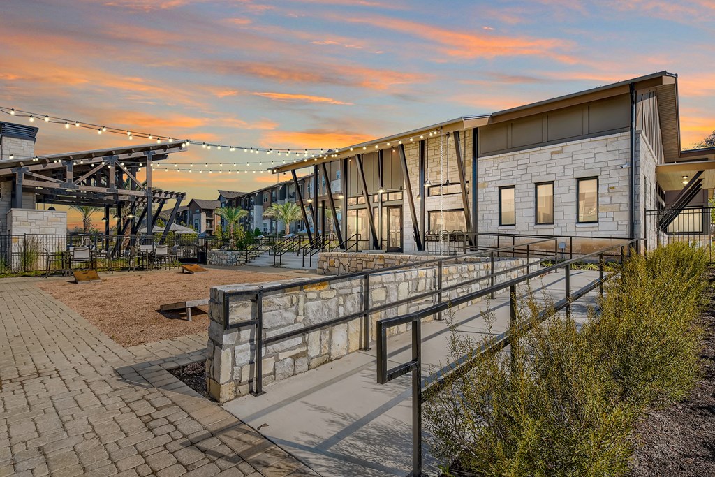 Communal space with lawn games  and cafe lighting at Cypress McKinney Falls in Austin, TX