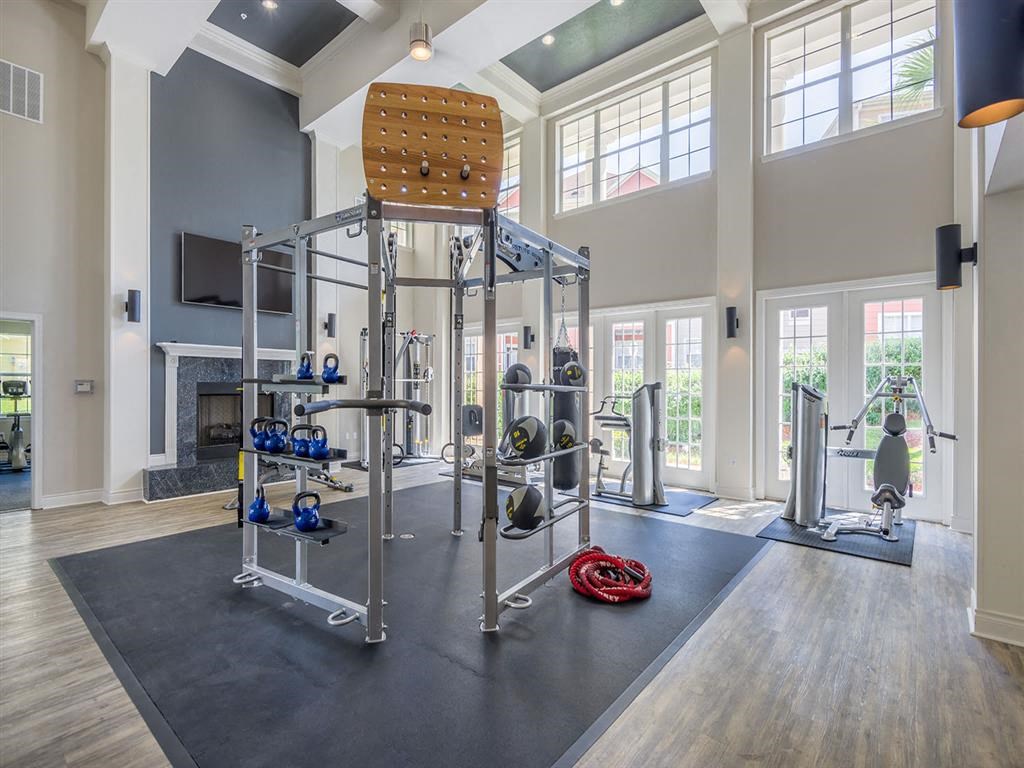 Tallahassee, FL apartment complex premium fitness center with exercise equipment, padded flooring and high ceiling at Evergreen at Mahan