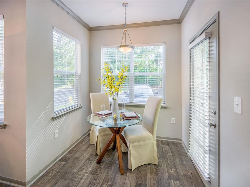 Separate dining area with numerous windows and door to private patio/balcony at Evergreens at Mahan apartments in Tallahassee, FL Separate dining area with numerous windows and door to private patio/balcony at Evergreens at Mahan apartments in Tallahassee, FL
