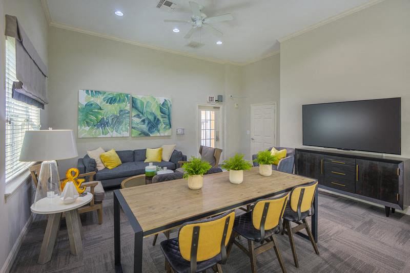 Furnished living room with sofas, dining table, wood-designed flooring and high ceiling Evergreens at Mahan apartments in Tallahassee, FL - Photo Gallery 1