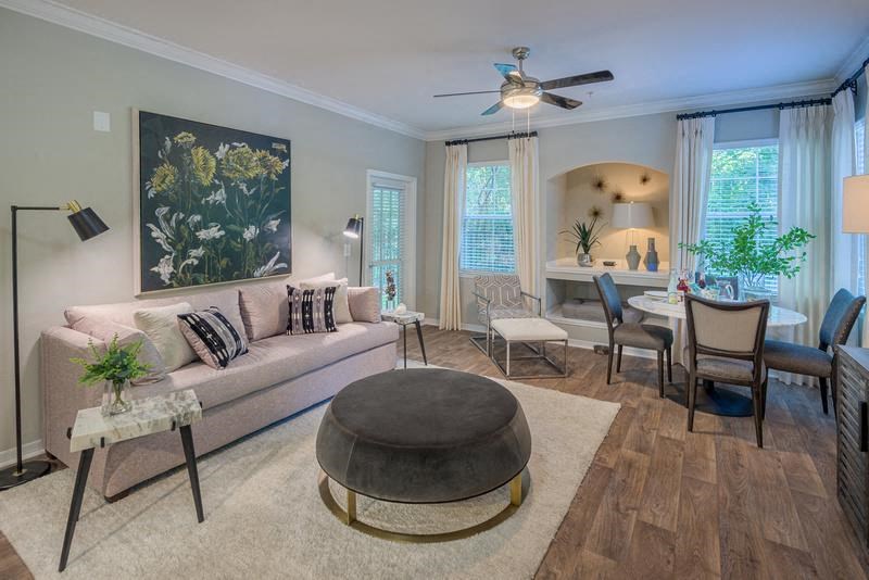 Tallahassee FL apartment furnished living room with sofa, coffee table, wood designed flooring, and high ceiling at Evergreens at Mahan