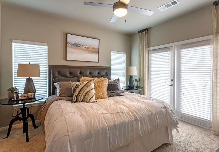 Furnished bedroom with ceiling fan at Lullwater at Blair Stone apartments for rent in Tallahassee, FL