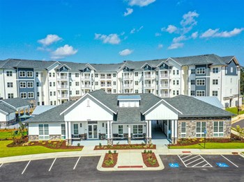 Looking down on The Station at Brighton community with resident clubhouse and leasing center in the front and residential buildings in the background - Photo Gallery 2