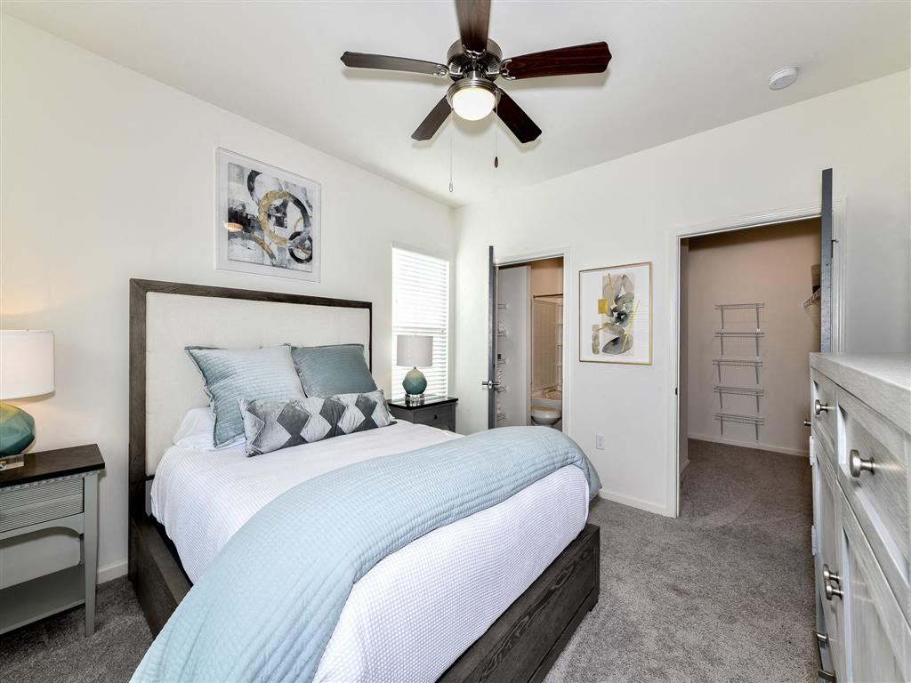 Furnished bedroom with walk-in closet and private bathroom at The Station at Brighton apartments for rent