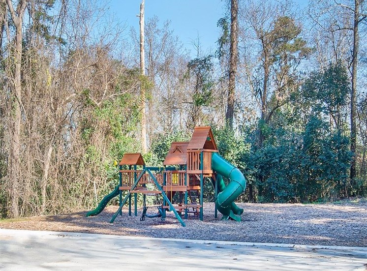 view of trees and playground at Magnolia Crossing apartments in Macon GA