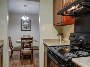 Looking from the kitchen into the dining area furnished with a circular table and 4 chairs at Ridgewood Apartments in Savannah, GA
