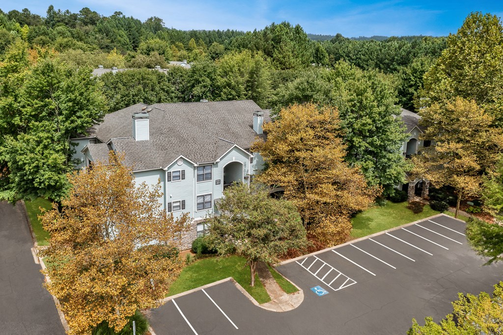 Aerial view of Heritage at Riverstone residential building and parking surrounded by lush trees