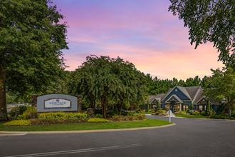 Property entrance with lush landscaping at Heritage at Riverstone apartments for rent in Canton, GA