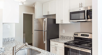 Kitchen with white shaker-style cabinets, granite countertops, and sleek appliances at Hunt Club in Gaithersburg, MD - Photo Gallery 4