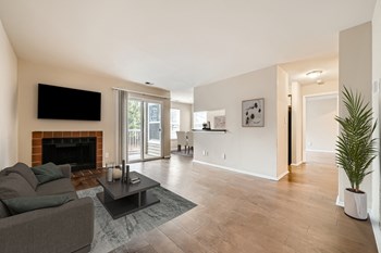 Living area with fireplace and wood-designed flooring at Hunt Club apartments for rent in Gaithersburg, MD - Photo Gallery 7