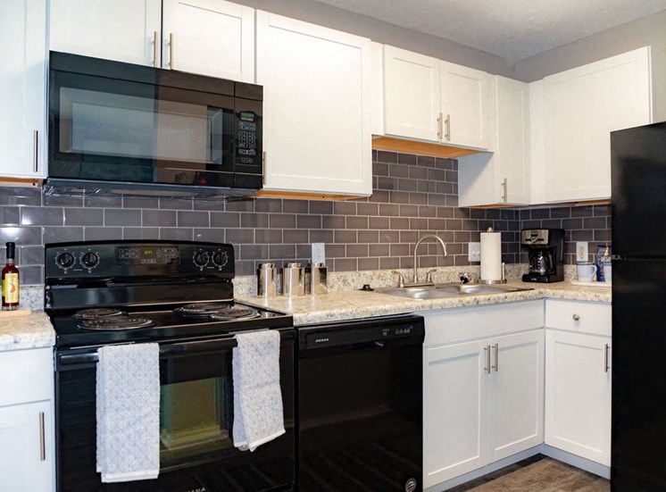 Forest Ridge kitchen interior with white cabinetry and black appliances