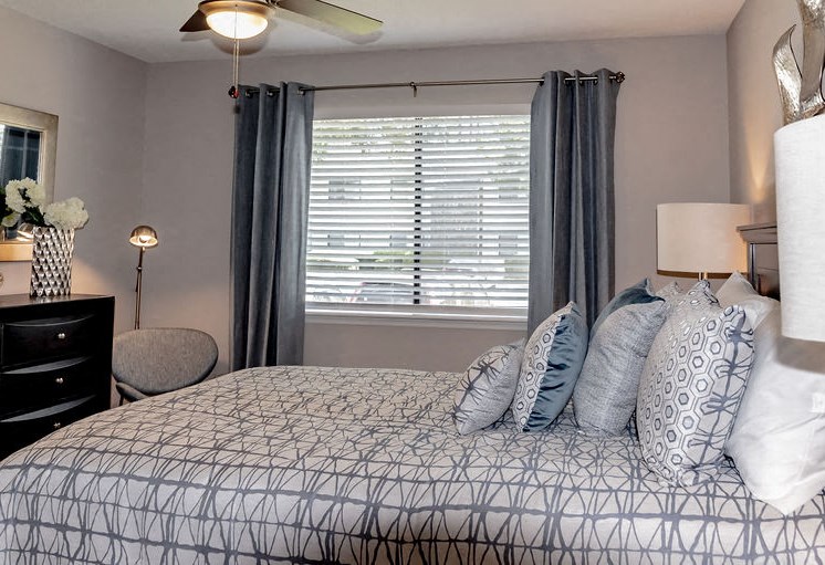 Full size bed with dresser and window in Forest Ridge apartment