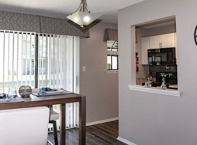Dining area with Kitchen through window in Forest Ridge apartment