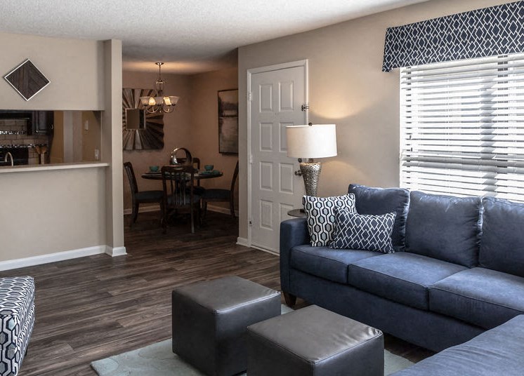 Living room with dining area and kitchen through wall at Forest Pointe apartment