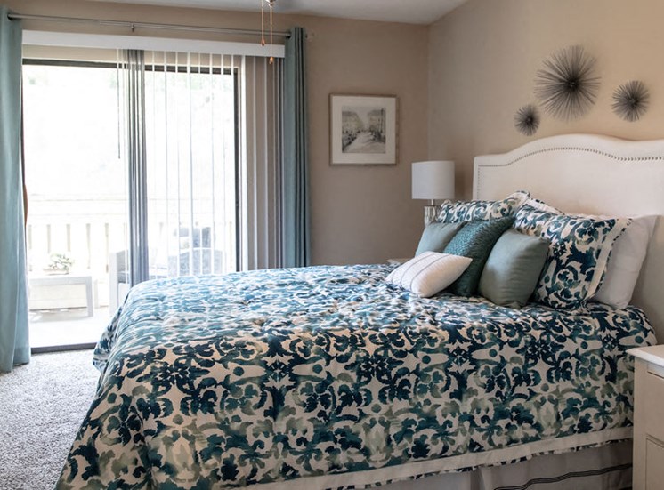 Bedroom with sliding glass door in Forest Pointe apartment