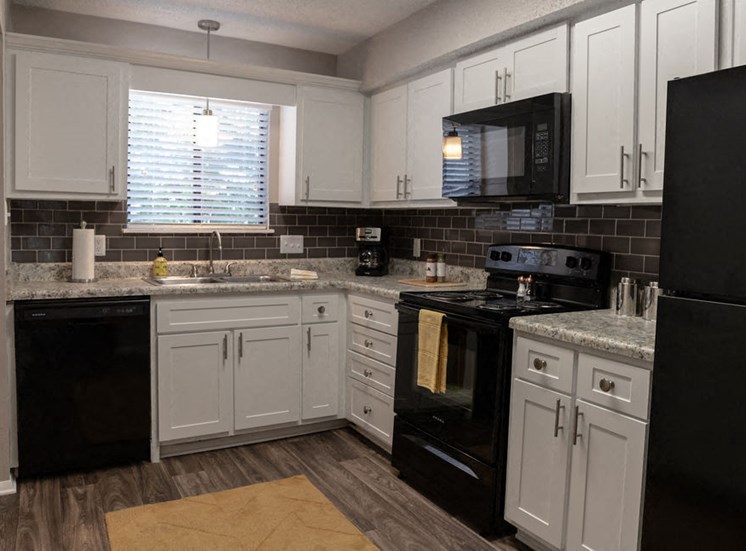 Macon GA apartment kitchen with black appliances and white modern cabinets