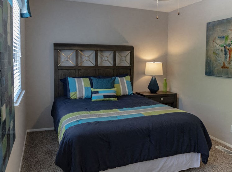 bedroom in an apartment in Macon with navy blue bedding and brown headboard