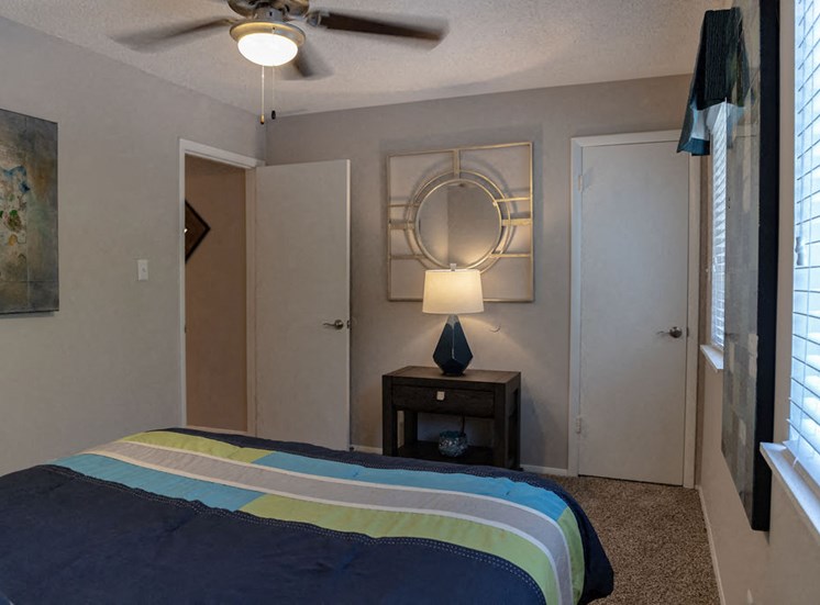 furnished apartment bedroom with ceiling fan and closet