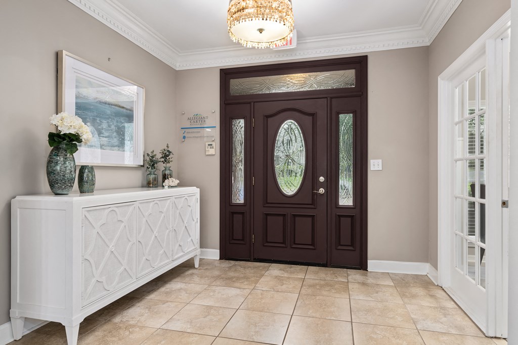 an entryway with a dark wooden front door and beige tile flooring