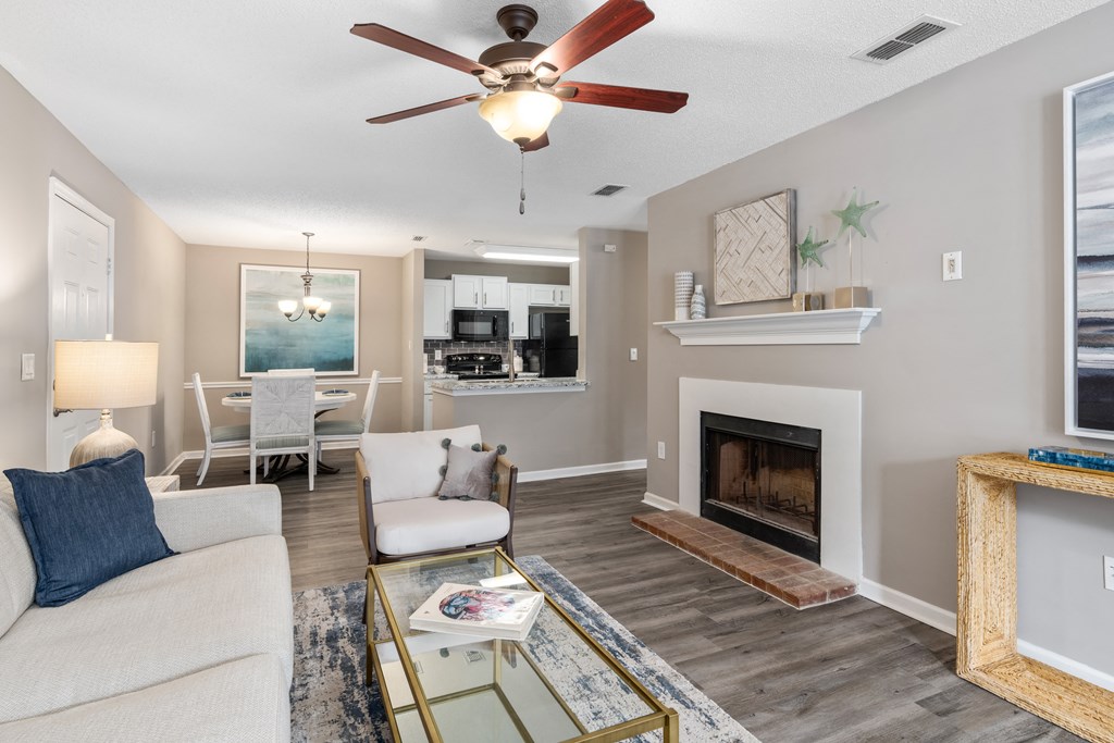 a living room with a fireplace and a ceiling fan