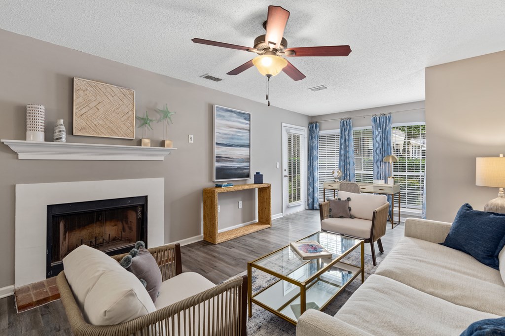a living room with a fireplace and a ceiling fan