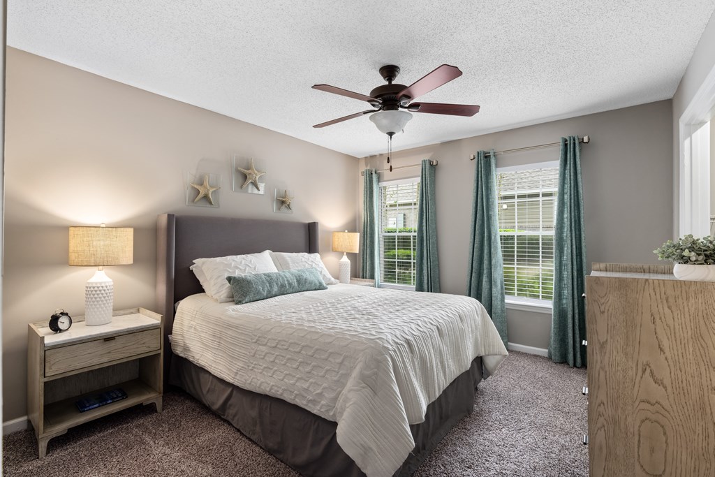 a bedroom with a bed and a ceiling fan
