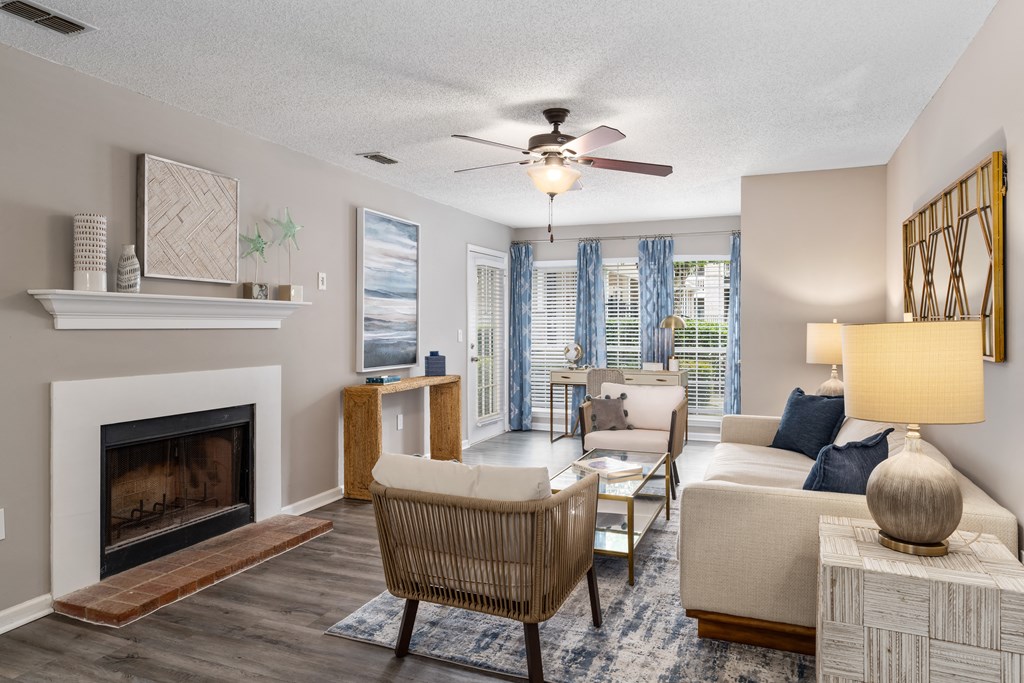 a living room with a fireplace and a ceiling fan